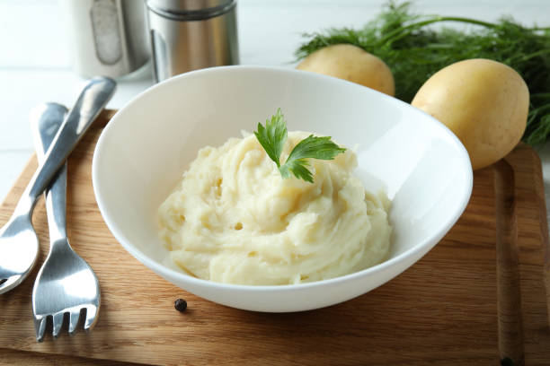 istock Concept of tasty eating with mashed potatoes on white wooden table 1439968076