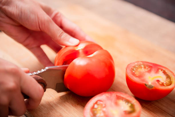 istock Preparing food, cutting tomatoes slices 1439969496