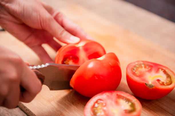 istock Preparing food, cutting tomatoes slices 1439969501