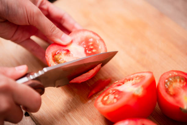 istock Preparing food, cutting tomatoes slices 1439969603
