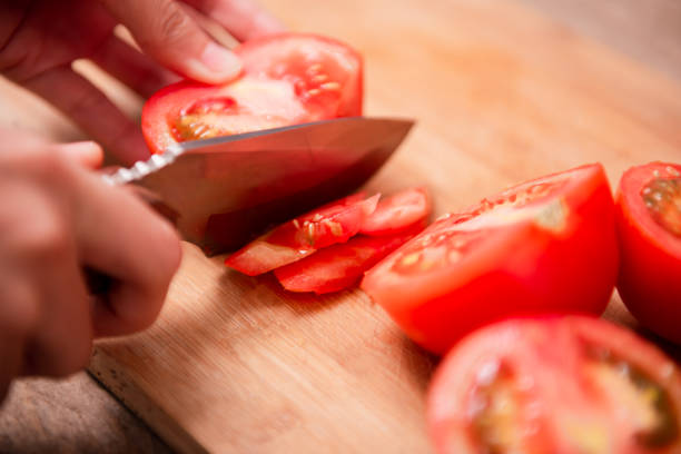 istock Preparing food, cutting tomatoes slices 1439969612