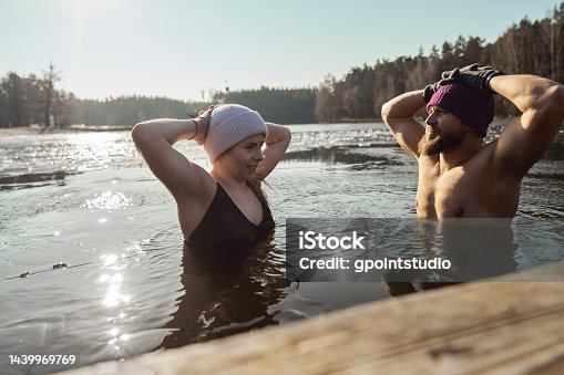 istock Caucasian couple swimming in frozen lake 1439969769