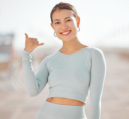 Woman, portrait and Hawaii surfer hand or flirting call me sign while taking outdoor sports break. Happy, friendly and welcome gesture symbol from popular culture for a young person greeting.