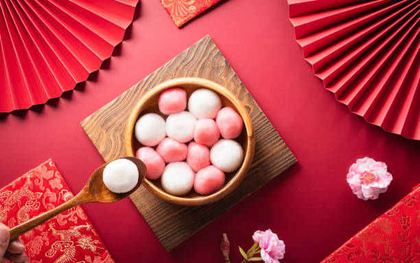tang yuan (dolci gnocchi palline), una cucina tradizionale per metà autunno, dongzhi (solstizio d'inverno) e capodanno cinese con fiori di prugna e tè su sfondo rosso. - zucca delicata foto e immagini stock