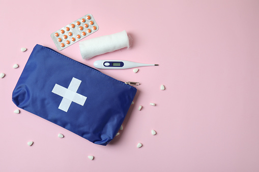 First aid medical kit on pink background