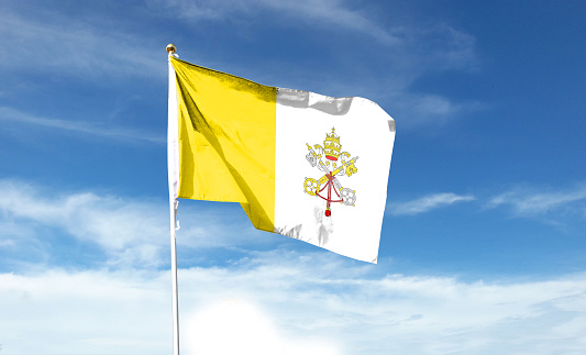 Vatican flag on cloudy sky. waving in the sky