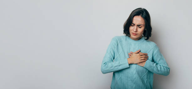 istock Young woman suffering from heart attack isolated on gray background 1439975580