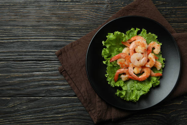 istock Plate with grilled shrimps on rustic wooden background 1439977363