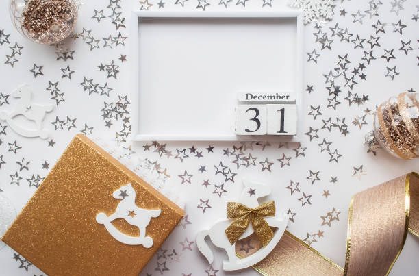 istock Christmas frame with white and gold decorations and a gift box on a white background. Flat layout, top view, place to copy. The concept of the new year 2023 1439978722