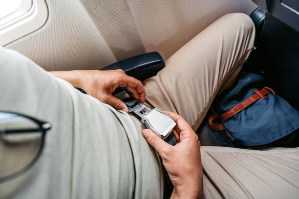 istock Young Man Fastening His Seatbelt In An Airplane 1439980214