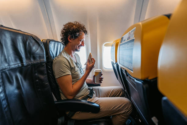 istock Young Man Eating A Sandwich And Drinking Coffee In An Airplane 1439980240