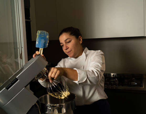 istock Young woman pastry chef making cookies in her bakery 1439981138