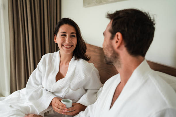 istock Smiling couple enjoying morning coffee in bed 1439982394
