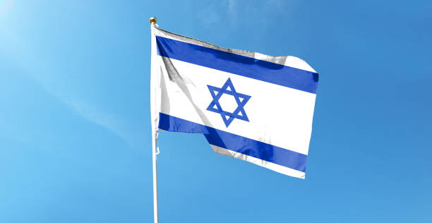 istock Israel flag on cloudy sky. waving in the sky 1439983035