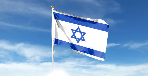 istock Israel flag on cloudy sky. waving in the sky 1439983183