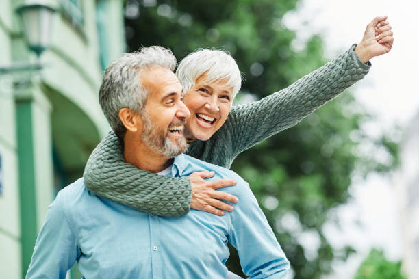 mujer hombre al aire libre pareja senior feliz estilo de vida jubilación juntos sonriente amor piggyback activo madura - senior adult fun autumn senior couple fotografías e imágenes de stock