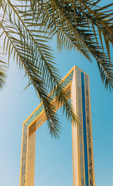 istock Vertical High quality photo. View Of Dubai Frame On Sunny Blue Sky Under Palm Branches. Dubai Frame Is Architectural Landmark In Zabeel Park, Dubai. It Holds Record For Largest Frame In The World. Travel Landmark Of UAE 1439989092