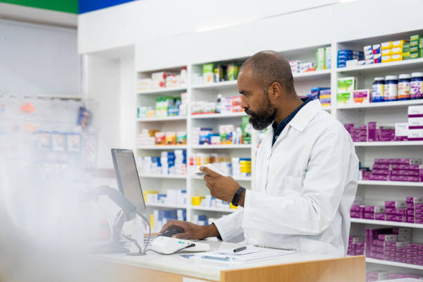 istock A male African-American pharmacist takes notes on medication inside pharmacy premises 1439989353