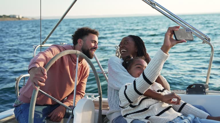 A teenage girl takes a selfie with her parents while sailing on a yacht