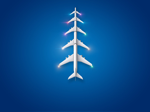 Christmas tree made of five airplanes on a blue background. Happy Holidays and Happy New Year background.