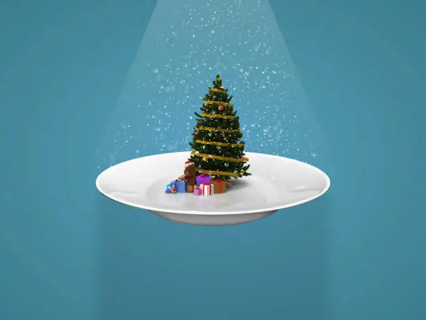 Decorative Christmas tree with gift boxes on the white plate on the sky blue background