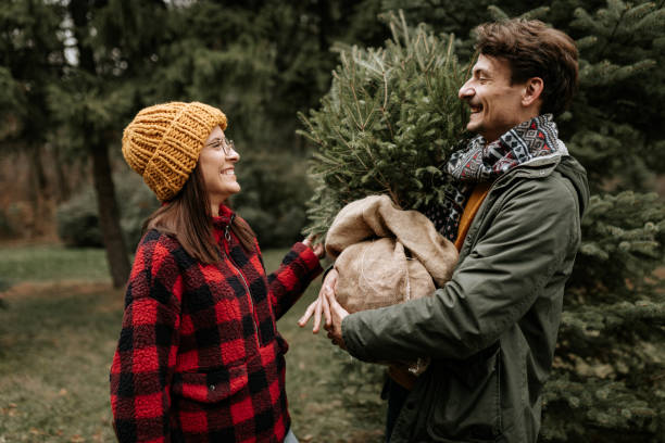 istock Happy couple having fun while carrying their new Christmas three 1439998283