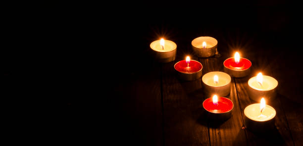 istock Set of candles lightening on dark table background 1439998312