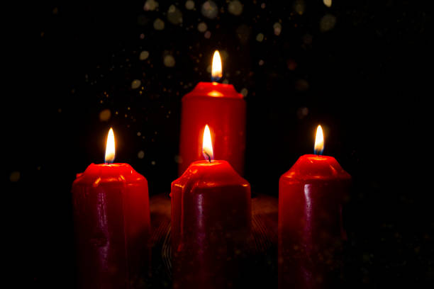 For red burning candles isolated black with mystery lights.