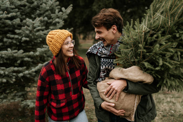 istock Happy couple having fun while carrying their new Christmas three 1439998451