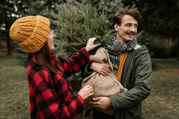 istock Happy couple having fun while carrying their new Christmas three 1439998539
