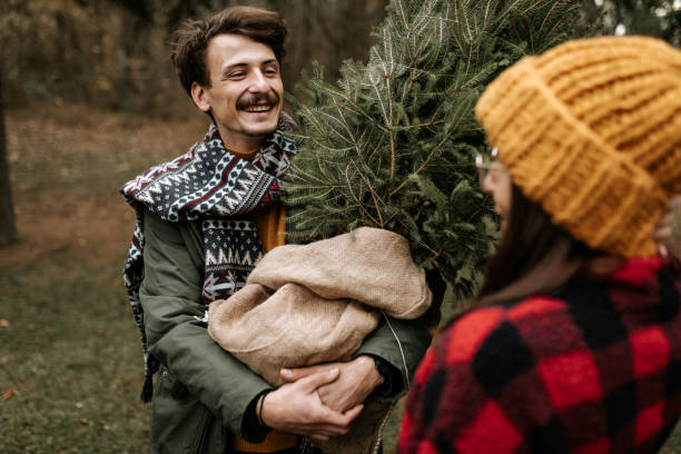 istock Happy couple having fun while carrying their new Christmas three 1439998740
