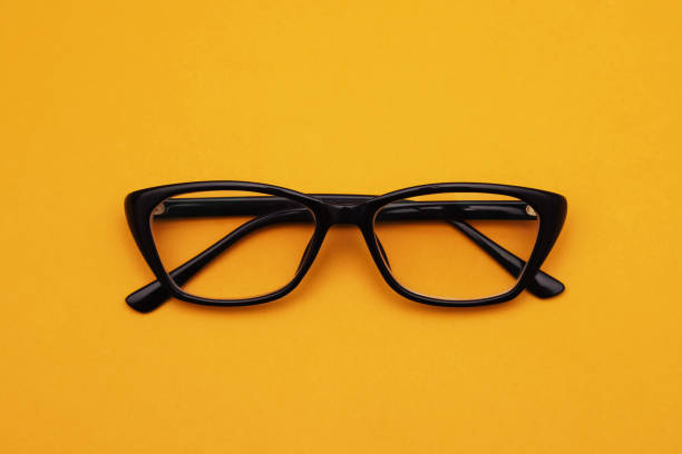 istock Glasses with diopters in a black frame on an orange background. Close-up 1440001491