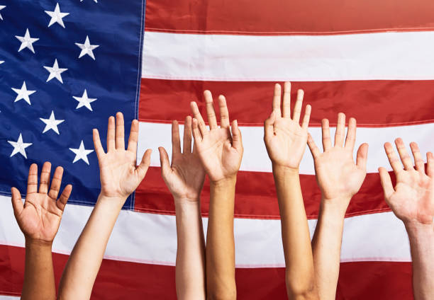 istock Diverse group of open hands, waving, against American flag 1440002467