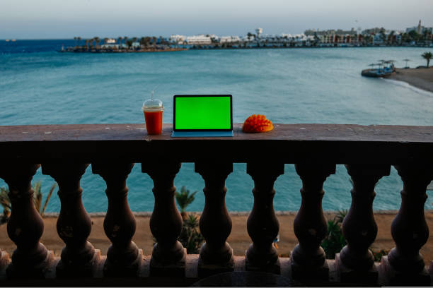 istock Tablet with green screen on balcony with seaview 1440005462