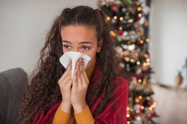 istock Young woman coming down with a flu blowing her nose 1440005497