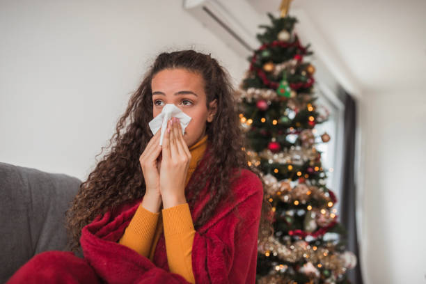 istock Young woman coming down with a flu blowing her nose 1440005554