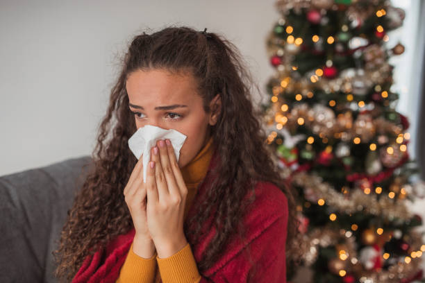 istock Young woman coming down with a flu blowing her nose 1440005583