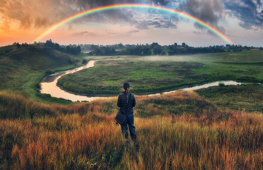 Woman Looking At Rainbow. rainbow over the autumn river. nature of Ukraine