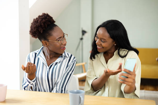 istock Two African American sisters having fun online together 1440008751