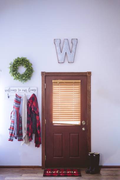 vertical shot of a door with welcoming words written on the door carpet and a signboard - doormat door christmas holiday imagens e fotografias de stock