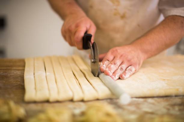 istock Professional chief making a pastry with dough in a kitchen 1440010463