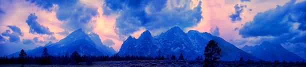 A panorama of a mesmerizing mountainous scenery under the cloudy sky with warm colors