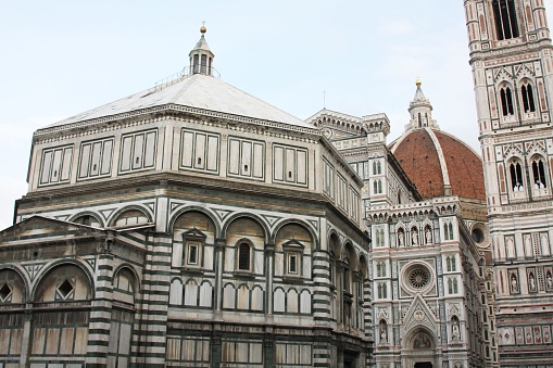 A low-angle of Piazza del Duomo, cloudy sky background, other buildings around, Florence, Italy