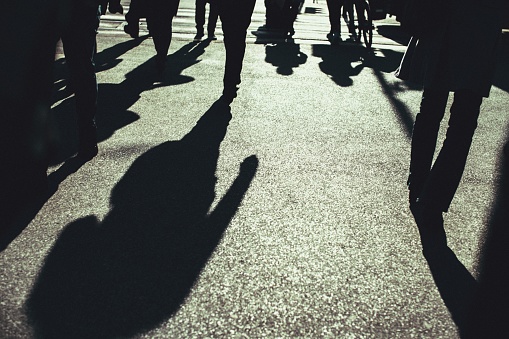 The shadow of the people on the asphalt crossing the street