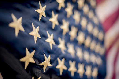 A blurred shot of a textile with needlework of the stars part of the  US flag