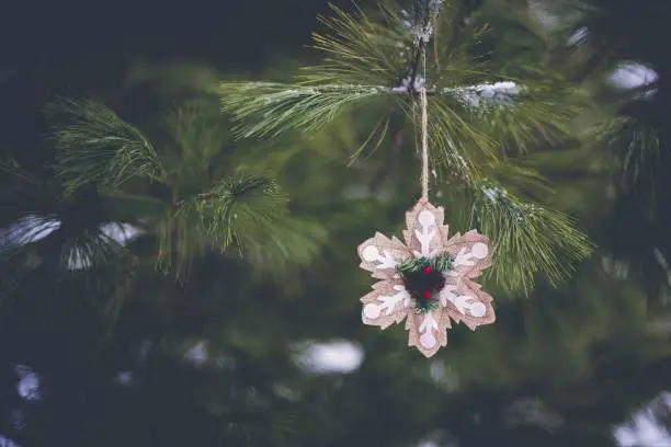 Photo of Closeup shot of a beautiful  snowflake-shaped ornament on the Christmas tree in winter