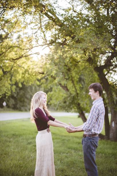istock Couple holding hands in a garden surrounded by greenery under sunlight with a blurry background 1440013577