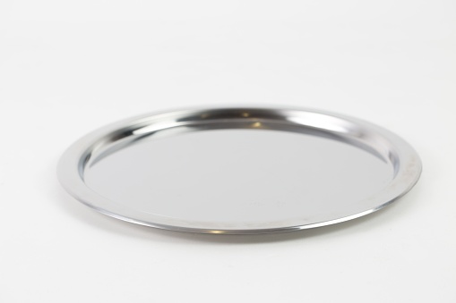 A closeup shot of a silver metal tray isolated on a white background