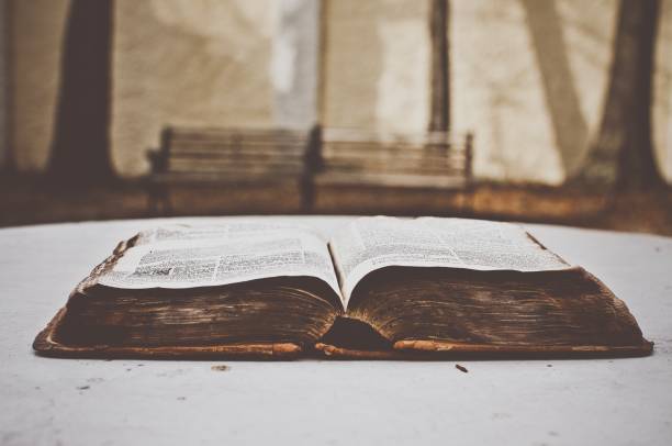 istock Closeup shot of an old opened bible on a white surface with a blurred background 1440014794