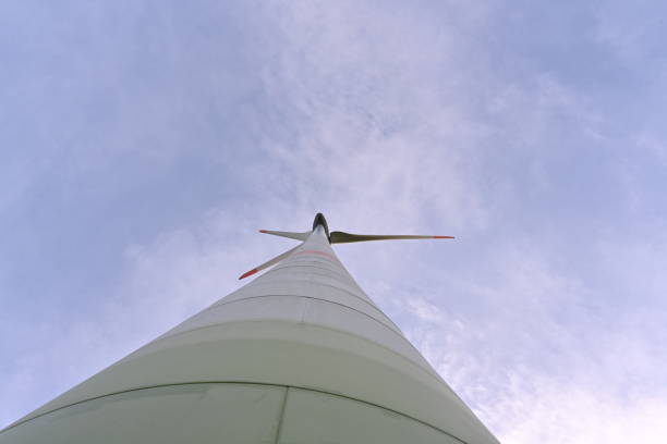 istock Low angle view on propeller and column of on-shore wind turbine against blue sky. 1440015122